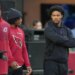 Injured Arizona Cardinals quarterback Kyler Murray, right, looks on as teammates warm up.