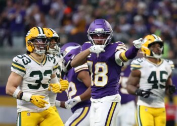 Minnesota Vikings wide receiver Justin Jefferson (18) celebrates in front of Green Bay Packers safety Evan Williams (33) after catching a pass.