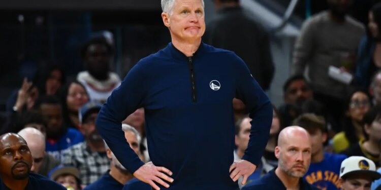 Golden State Warriors head coach Steve Kerr stands with his hands on his hips while looking at the court.
