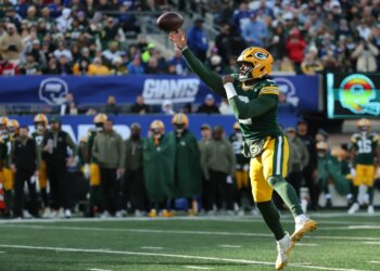 A Green Bay Packers player throws a football at MetLife Stadium.