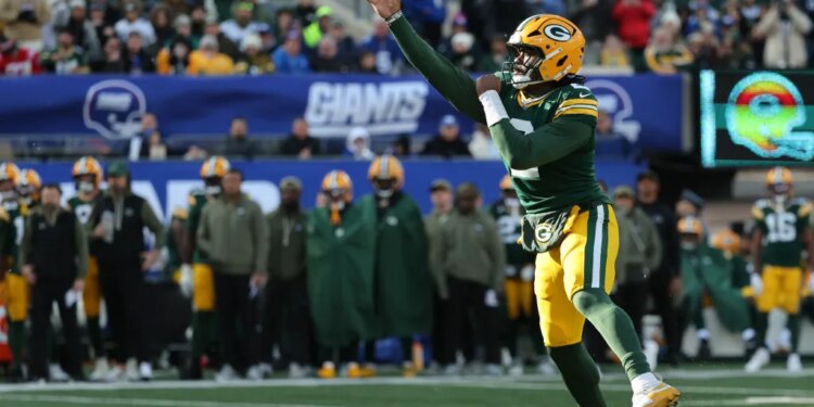 A Green Bay Packers player throws a football at MetLife Stadium.