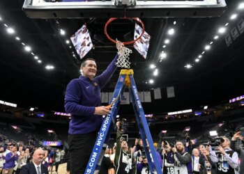 A Northern Iowa Panthers basketball coach cutting down the net after winning the Missouri Valley Conference Tournament.
