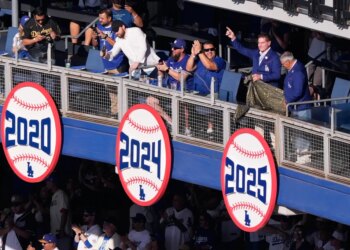 Former Dodgers player Steve Garvey gestures next to former announcer Jaime Jarrín after unveiling a sign celebrating the team's 2025 World Series Championship.