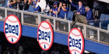 Former Dodgers player Steve Garvey gestures next to former announcer Jaime Jarrín after unveiling a sign celebrating the team's 2025 World Series Championship.