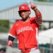 Abraham Toro, wearing a red "CANADA" jersey, red helmet, and eye black, points his right index finger upwards while celebrating during a baseball game.