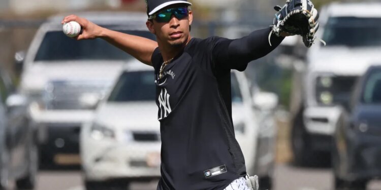 New York Yankees third baseman Oswaldo Cabrera throwing a ball during practice.