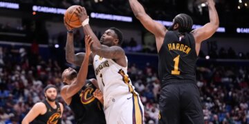Zion Williamson (1) drives to the basket against Cleveland Cavaliers center Evan Mobley (4) and guard James Harden (1) in the second half of an NBA basketball game, Saturday, March 21, 2026, in New Orleans.
