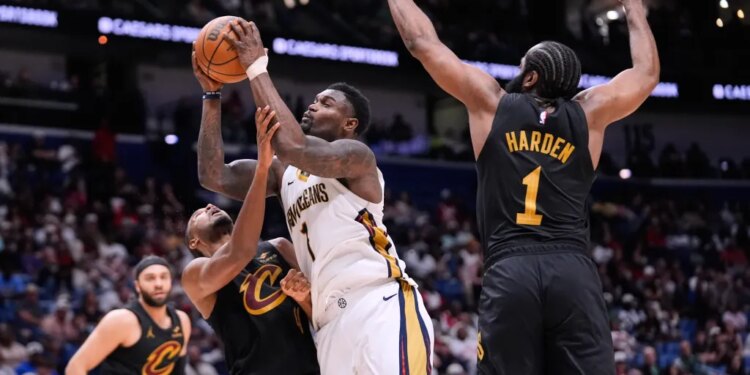 Zion Williamson (1) drives to the basket against Cleveland Cavaliers center Evan Mobley (4) and guard James Harden (1) in the second half of an NBA basketball game, Saturday, March 21, 2026, in New Orleans.