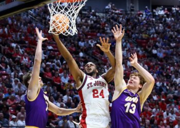 St. John's Red Storm forward Zuby Ejiofor #24 shooting a basketball over Northern Iowa Panthers players Ben Schwieger #7 and Will Hornseth #13 at the NCAA Tournament.