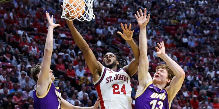 St. John's Red Storm forward Zuby Ejiofor #24 shooting a basketball over Northern Iowa Panthers players Ben Schwieger #7 and Will Hornseth #13 at the NCAA Tournament.