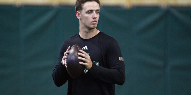 Miami quarterback Carson Beck holds a football, looking to his right.