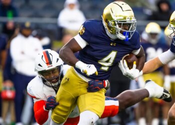 Notre Dame running back Jeremiyah Love getting past Virginia linebacker Kam Robinson during an NCAA college football game.