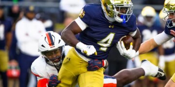 Notre Dame running back Jeremiyah Love getting past Virginia linebacker Kam Robinson during an NCAA college football game.