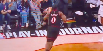 A basketball player high-fiving fans in the stands.