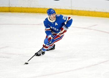 Rangers defenseman Adam Fox (23) skates with the puck.