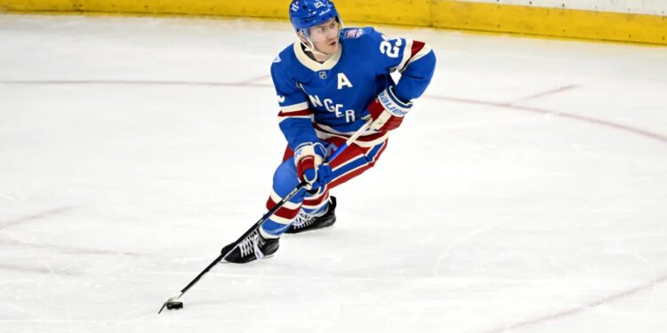 Rangers defenseman Adam Fox (23) skates with the puck.