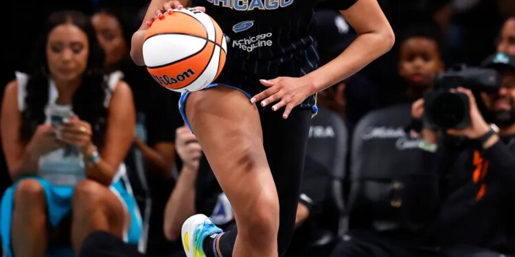 A Chicago Sky basketball player dribbles the ball down the court during a game.