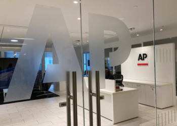 The Associated Press logo is shown at the entrance to the news organization's office.
