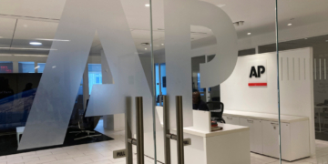 The Associated Press logo is shown at the entrance to the news organization's office.