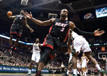 Miami Heat's Dwyane Wade reacting as teammate LeBron James goes up for a dunk against the Milwaukee Bucks.