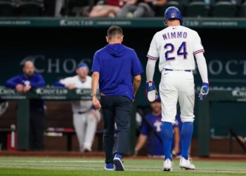 Texas Rangers' Brandon Nimmo (24) walks off the field with head athletic trainer Matt Lucero after suffering an unknon injury in the fifth inning of a baseball game against the Texas Rangers Wednesday, April 29, 2026, in Arlington, Texas.