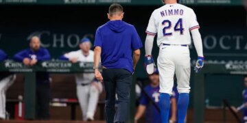 Texas Rangers' Brandon Nimmo (24) walks off the field with head athletic trainer Matt Lucero after suffering an unknon injury in the fifth inning of a baseball game against the Texas Rangers Wednesday, April 29, 2026, in Arlington, Texas.