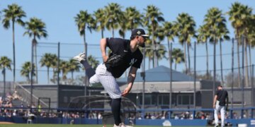 New York Yankees pitcher Carlos Rodón #55 throws in the outfield.