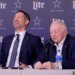Brian Schottenheimer laughing as Jerry Jones responds to a question at a press conference.