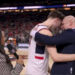 A basketball player and coach embrace on the court during an interview, with a "FINAL FOUR" logo visible in the background.