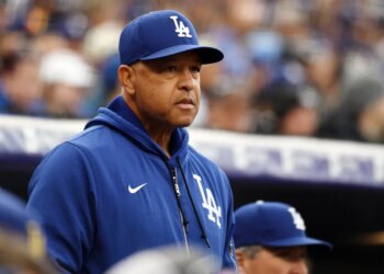 Los Angeles Dodgers manager Dave Roberts watching from the dugout during a baseball game.