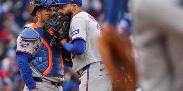 New York Mets catcher Luis Torrens talks with relief pitcher Devin Williams.