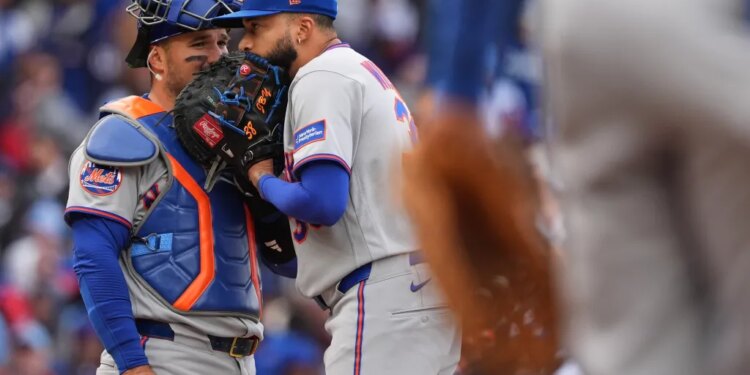 New York Mets catcher Luis Torrens talks with relief pitcher Devin Williams.