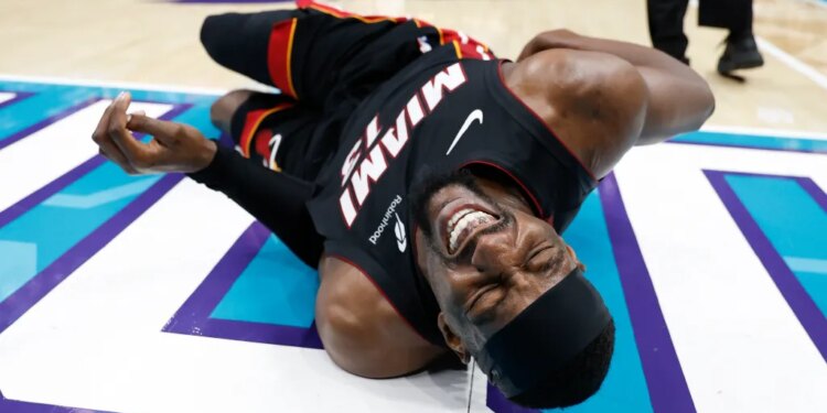 Heat center Bam Adebayo writhes in pain after getting tripped by the Hornets' LaMelo Ball in the second quarter on April 14, 2026.