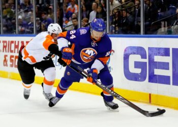 Philadelphia Flyers player Braydon Coburn checks New York Islanders player Mikhail Grabovski during an NHL hockey game.