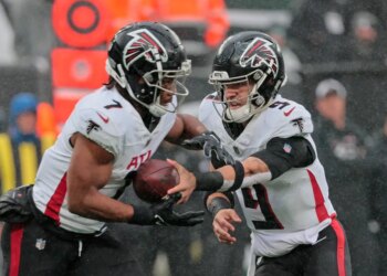 Atlanta Falcons #9 Desmond Ridder hands the ball to #7 Bijan Robinson.