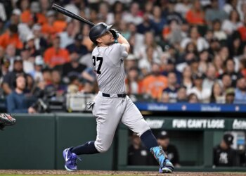 New York Yankees designated hitter Giancarlo Stanton (27) hits the ball in the third inning against the Houston Astros at Daikin Park.