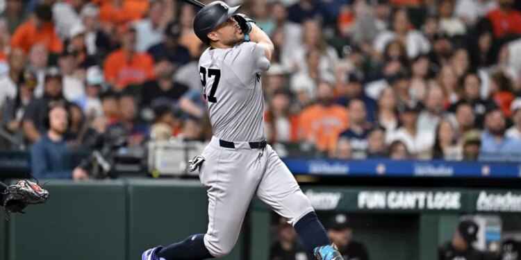 New York Yankees designated hitter Giancarlo Stanton (27) hits the ball in the third inning against the Houston Astros at Daikin Park.