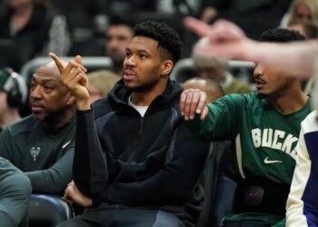 Milwaukee Bucks' Giannis Antetokounmpo gestures from the bench.