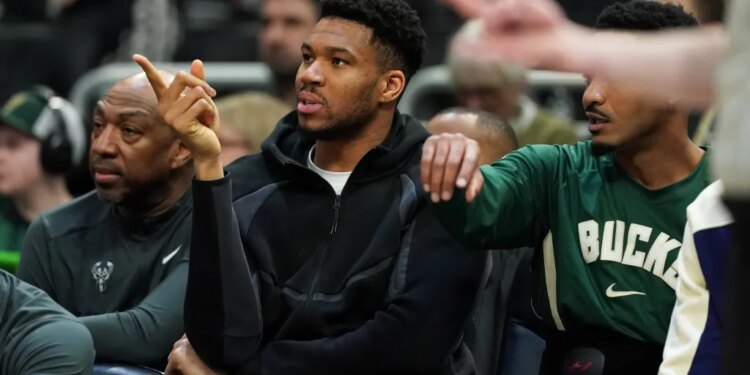 Milwaukee Bucks' Giannis Antetokounmpo gestures from the bench.