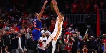 Basketball players CJ McCollum and Miles McBride jump for the ball during an NBA Playoffs game.