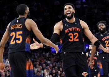 A smiling Karl-Anthony Towns celebrates with Mikal Bridges during the Knicks' Game 5 blowout win over the Hawks.
