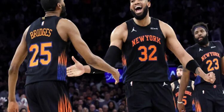 A smiling Karl-Anthony Towns celebrates with Mikal Bridges during the Knicks' Game 5 blowout win over the Hawks.