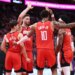 Houston Rockets players Alperen Sengun, Jabari Smith Jr., Amen Thompson, and another teammate huddle together.