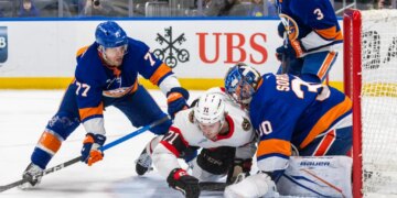 New York Islanders defenseman Tony DeAngelo (77) checks Ottawa Senators center Ridly Greig (71) during the second period at UBS Arena, Saturday, April 11, 2026, in Elmont, NY.