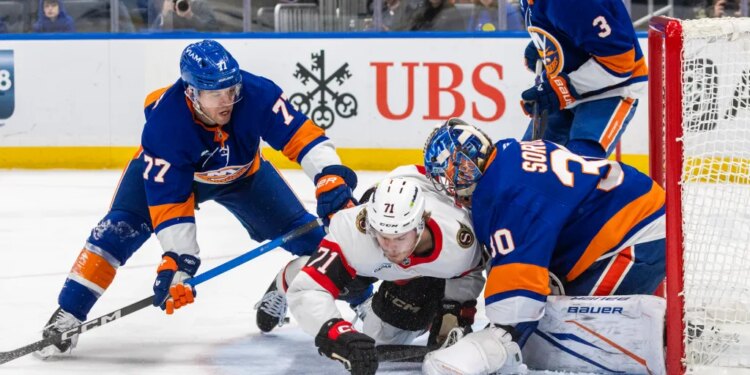 New York Islanders defenseman Tony DeAngelo (77) checks Ottawa Senators center Ridly Greig (71) during the second period at UBS Arena, Saturday, April 11, 2026, in Elmont, NY.