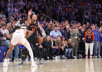 New York Knicks guard Jalen Brunson holding a basketball and calling a play against the Atlanta Hawks in the NBA playoffs.