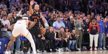 New York Knicks guard Jalen Brunson holding a basketball and calling a play against the Atlanta Hawks in the NBA playoffs.