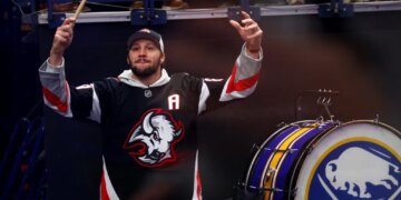 Buffalo Bills quarterback Josh Allen hyping up the crowd at a Buffalo Sabres game.
