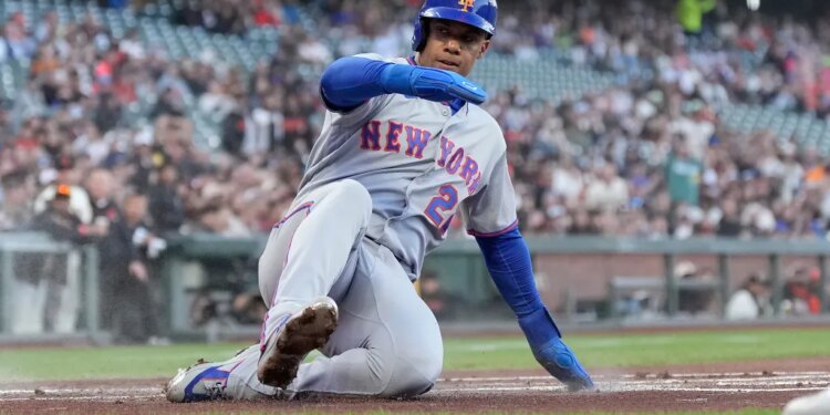Juan Soto of the New York Mets sliding into home plate.