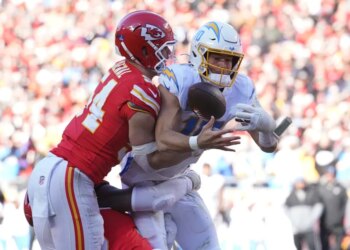 Kansas City Chiefs linebacker Leo Chenal hitting Los Angeles Chargers quarterback Justin Herbert during a game.